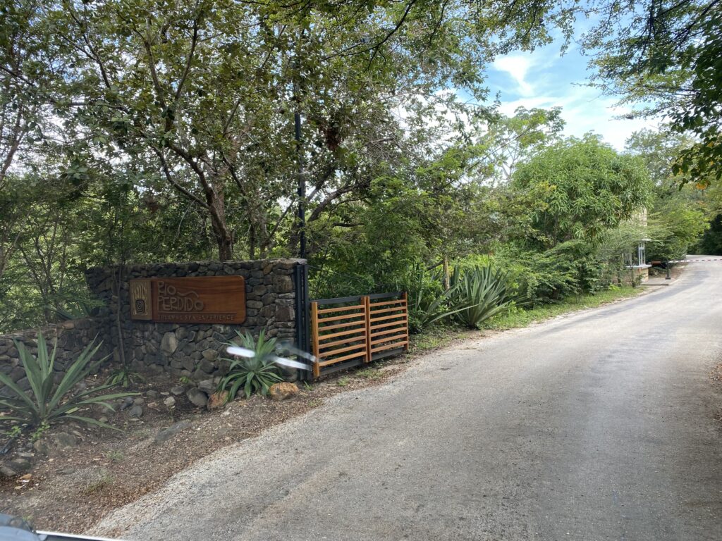 a road with trees and a sign on the side