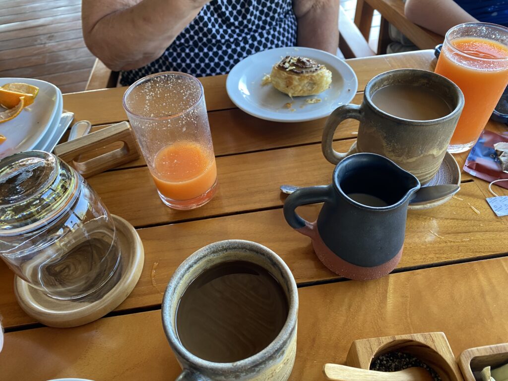 a table with cups of coffee and a pastry