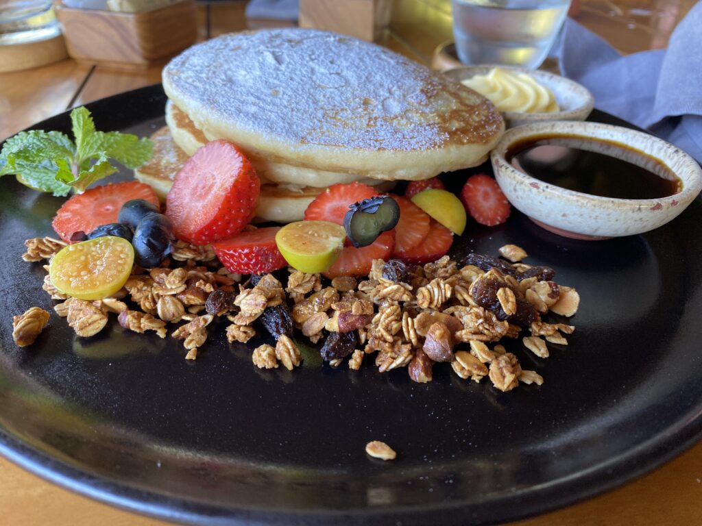 a plate of pancakes with fruit and cereal