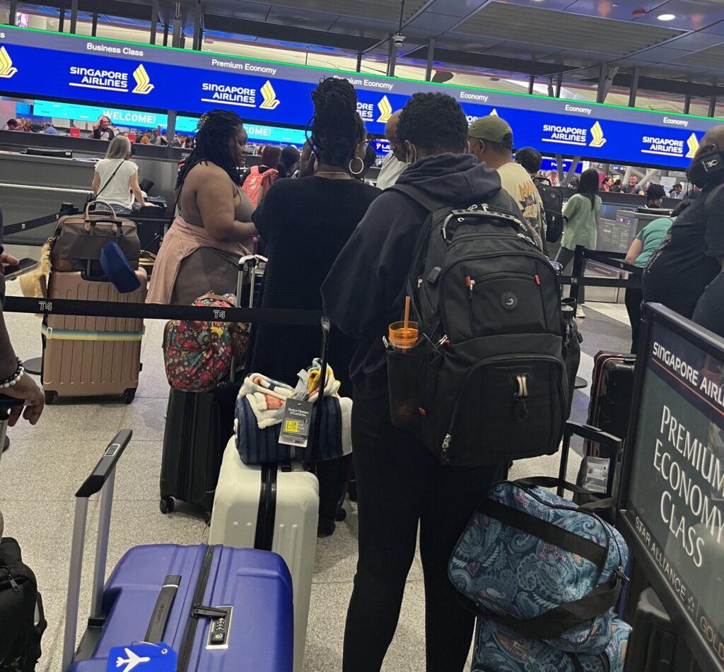 a group of people with luggage at an airport