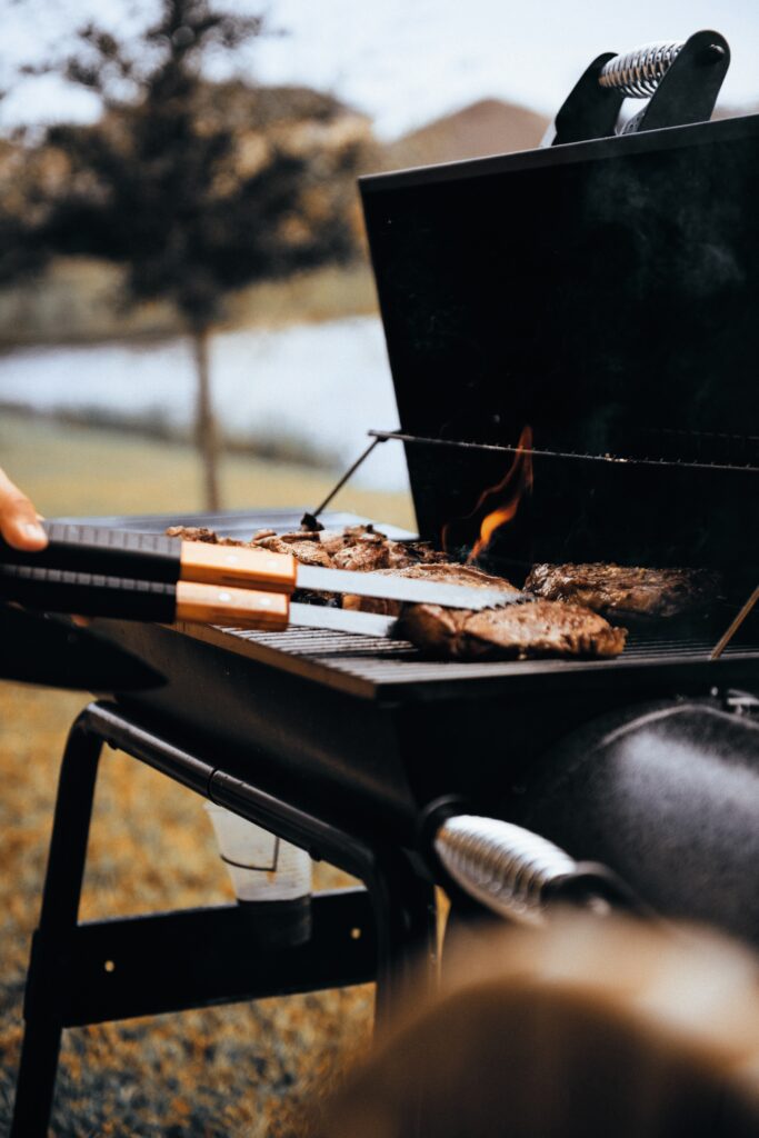 a person cooking meat on a grill