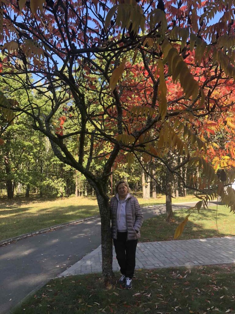 a woman standing next to a tree