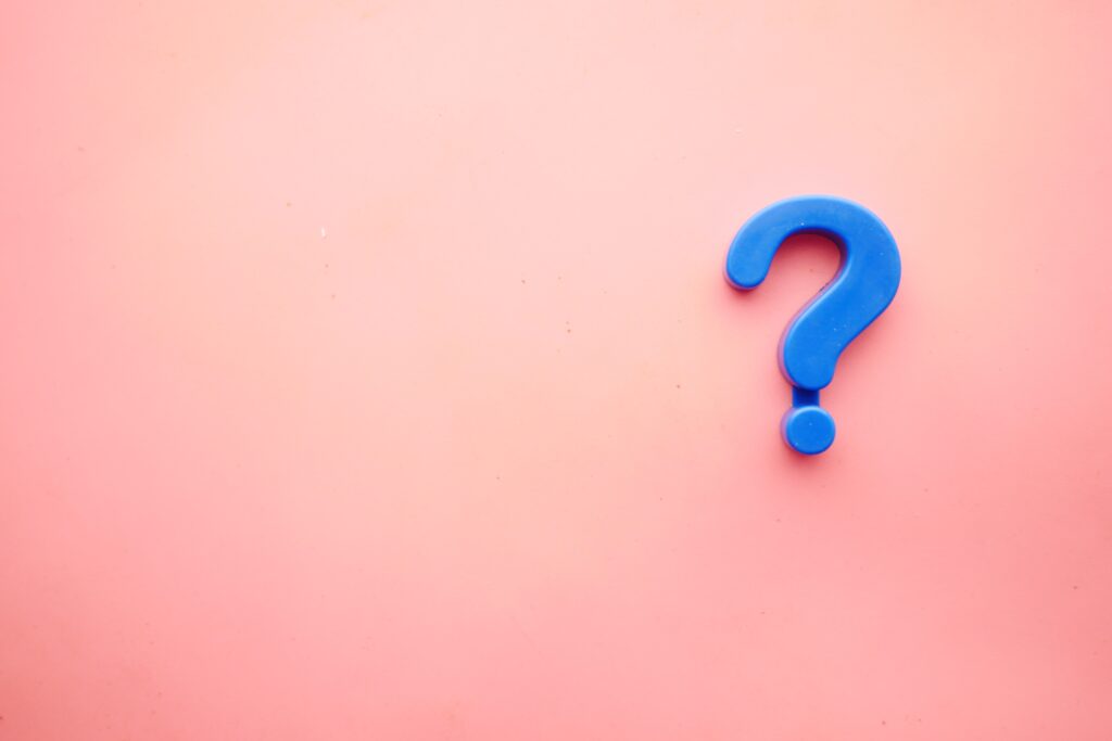a blue question mark on a pink surface