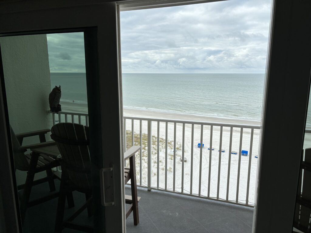 a balcony with a view of the ocean and chairs