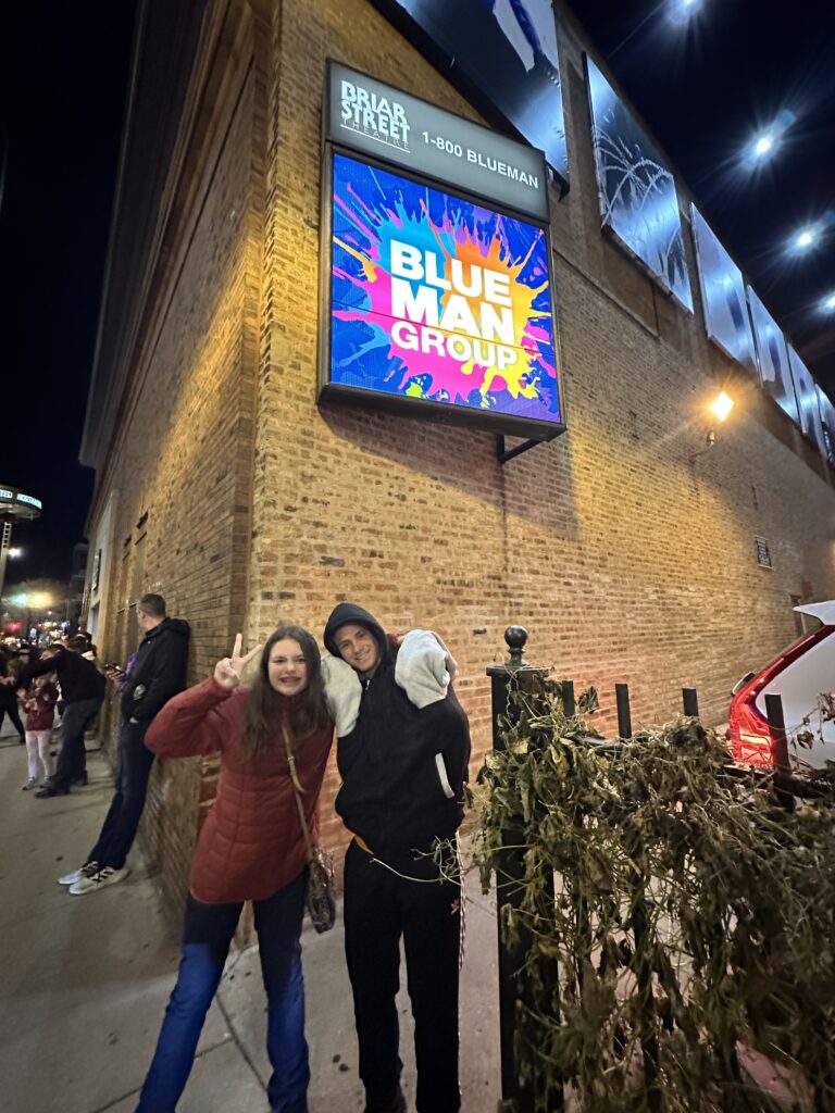 a man and woman posing for a picture in front of a building