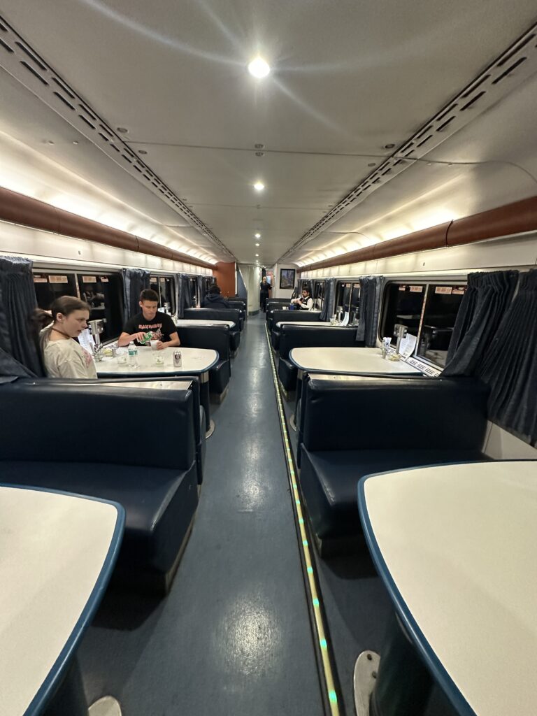 a couple of people sitting at tables in a train