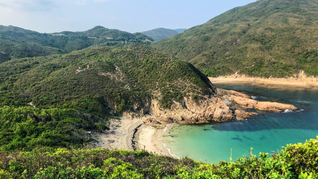 a beach with a body of water and hills