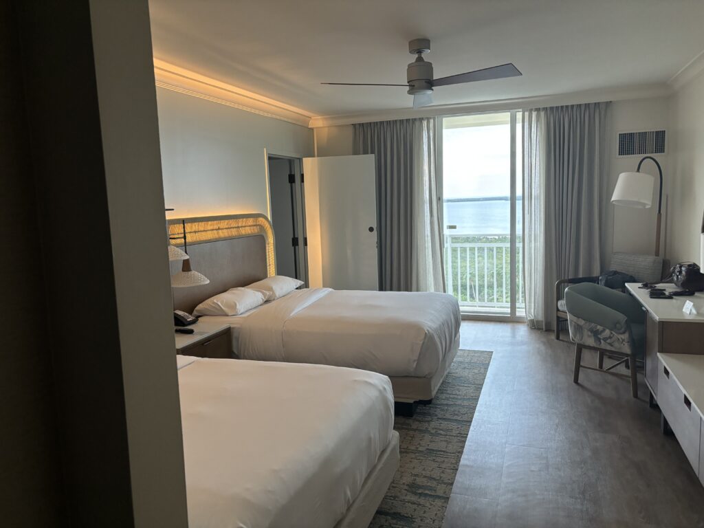 a room with two beds and a large window