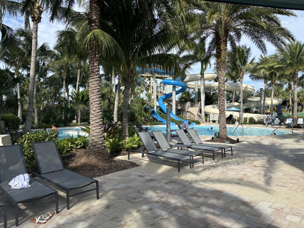 a pool with lounge chairs and a slide
