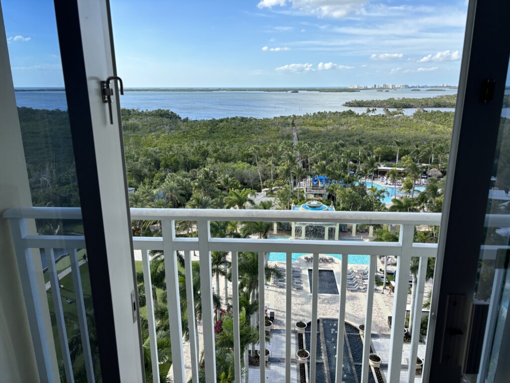 a view of a pool and trees from a balcony