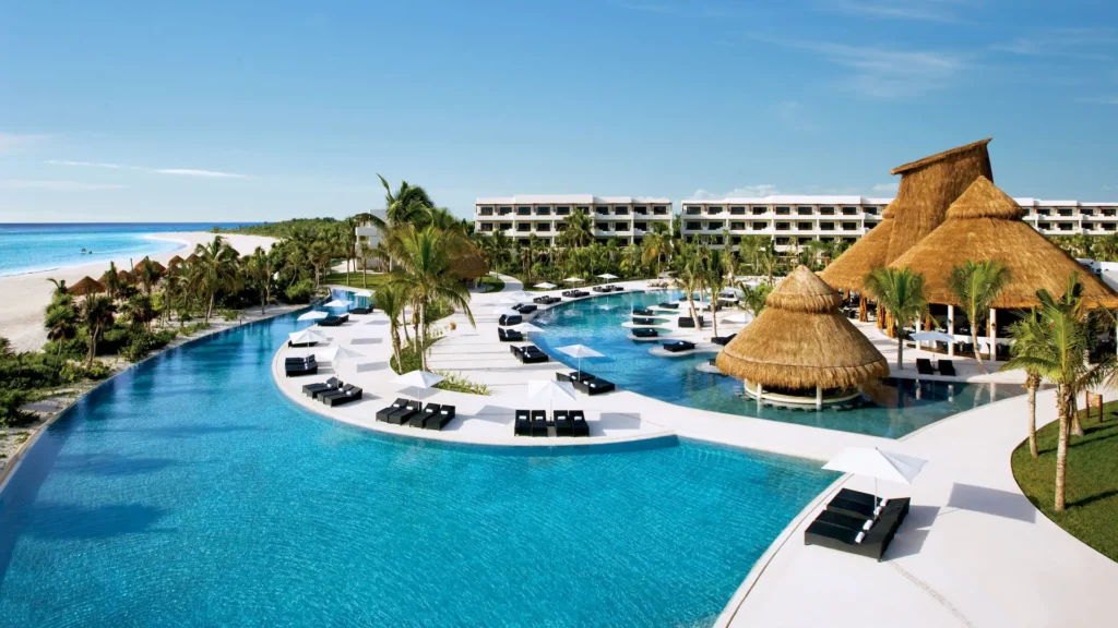 a pool with lounge chairs and a thatched roof