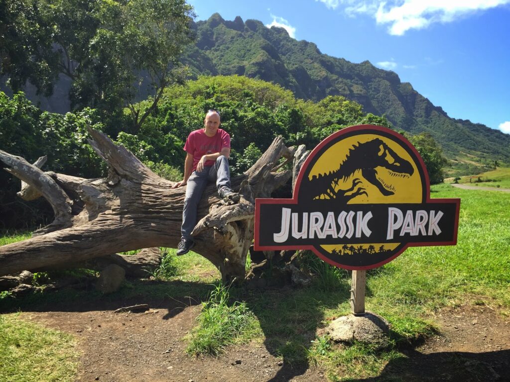 a man sitting on a log in front of a sign