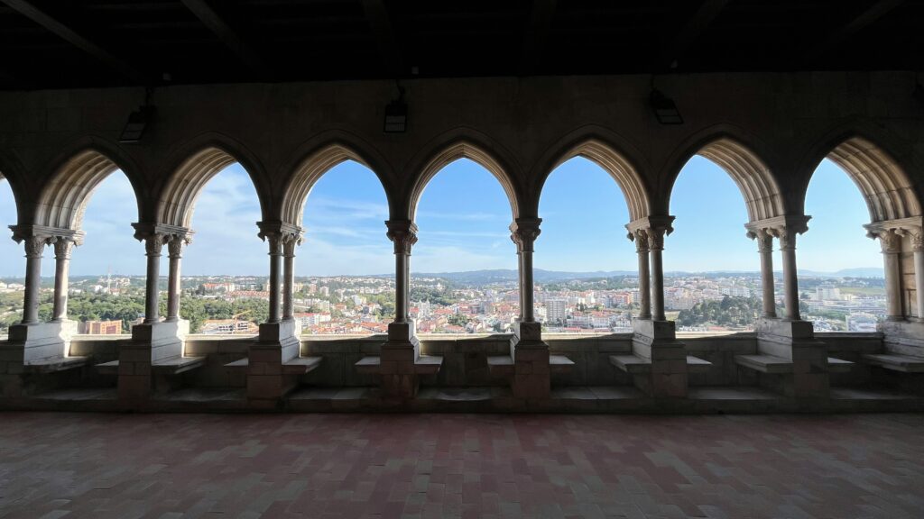 a group of stone benches in a room with a city in the background