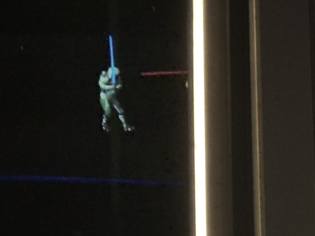 a person in a garment holding a light saber