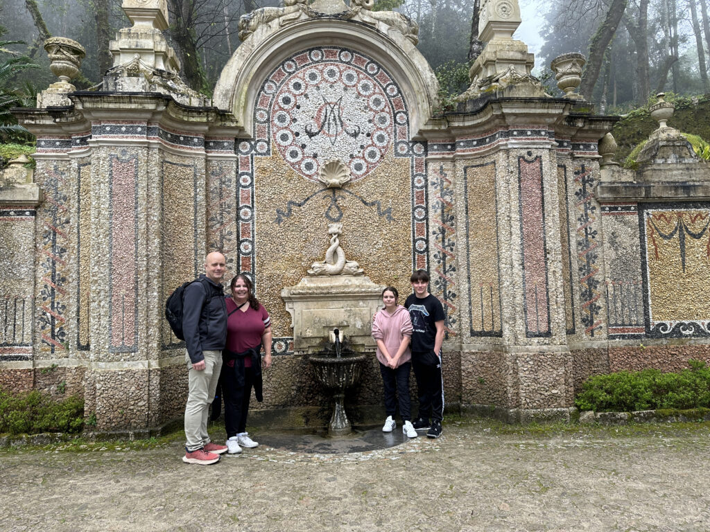 a group of people standing in front of a fountain