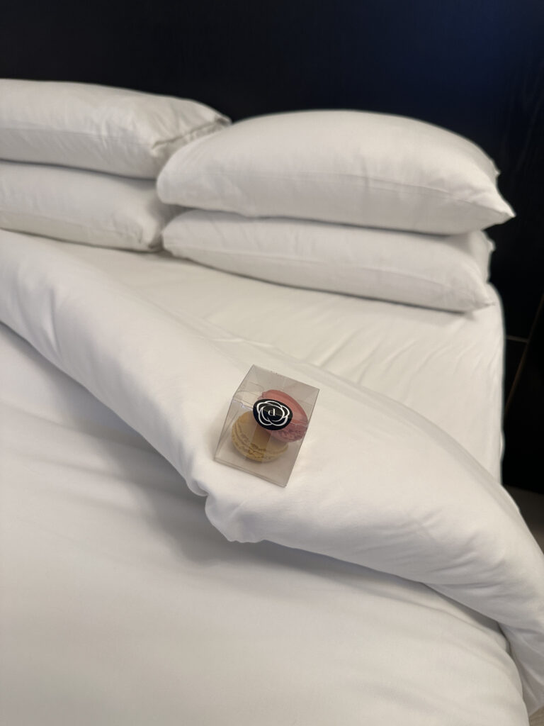 a stack of white pillows on a bed