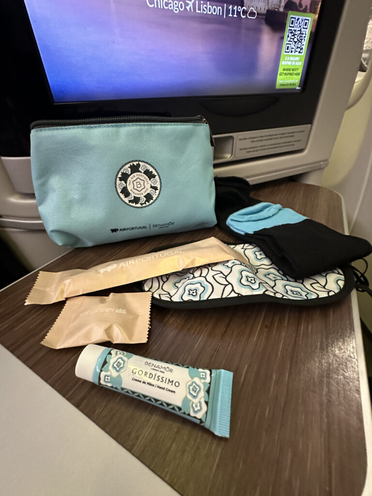 a small blue bag with a blue and white design on a table with a pair of socks and a tube of cream