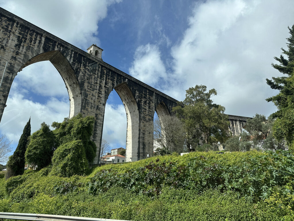 a stone bridge with trees and bushes