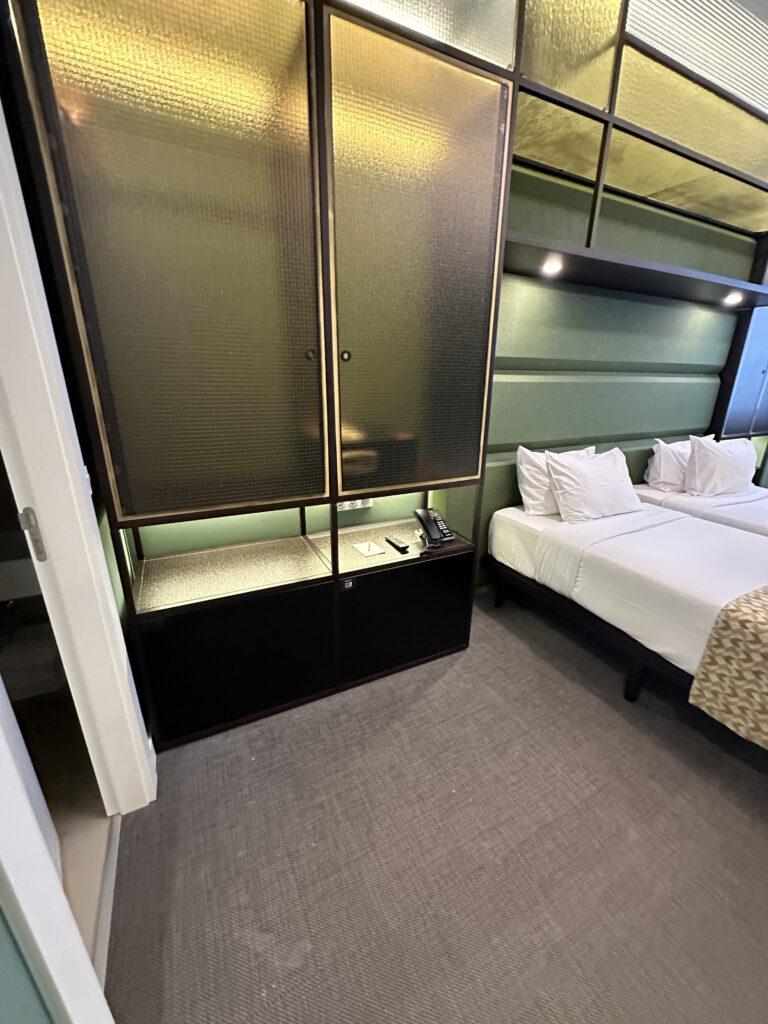 a room with two beds and a cabinet