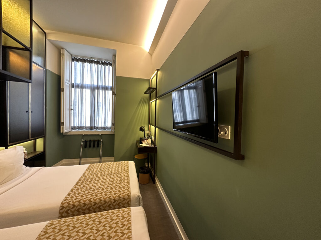 a room with two beds and a tv on the wall