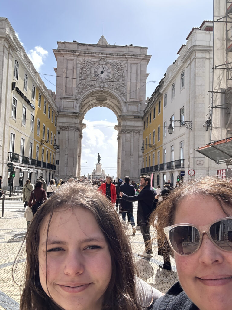 two women taking a selfie in front of a large archway