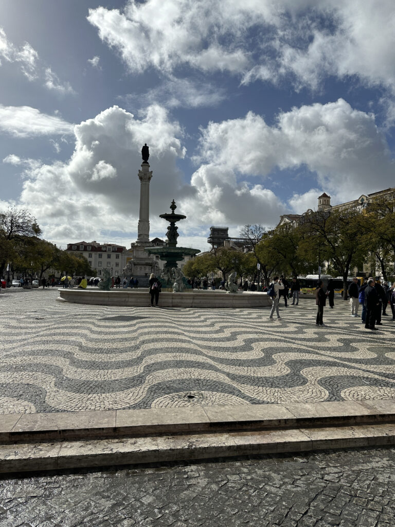 a group of people walking around a fountain