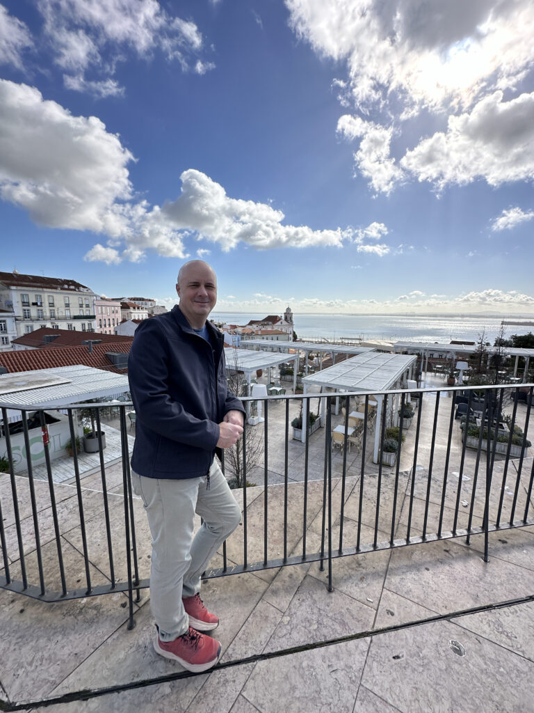 a man standing on a balcony with a city in the background