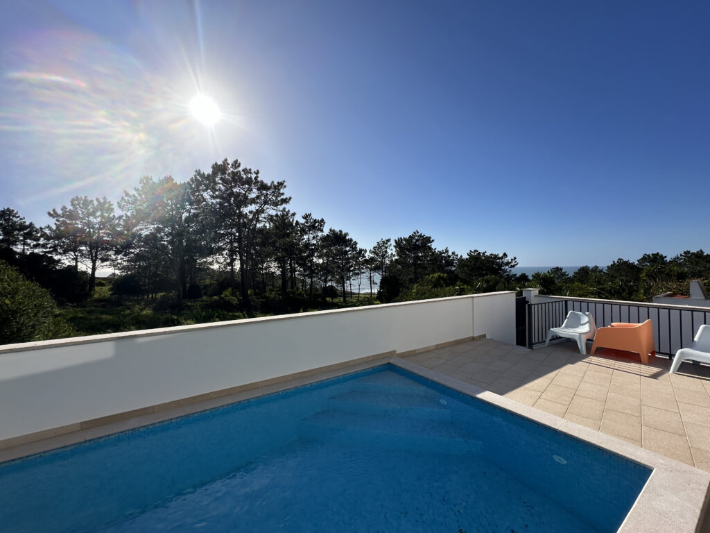 a pool on a deck with trees and a sunny day