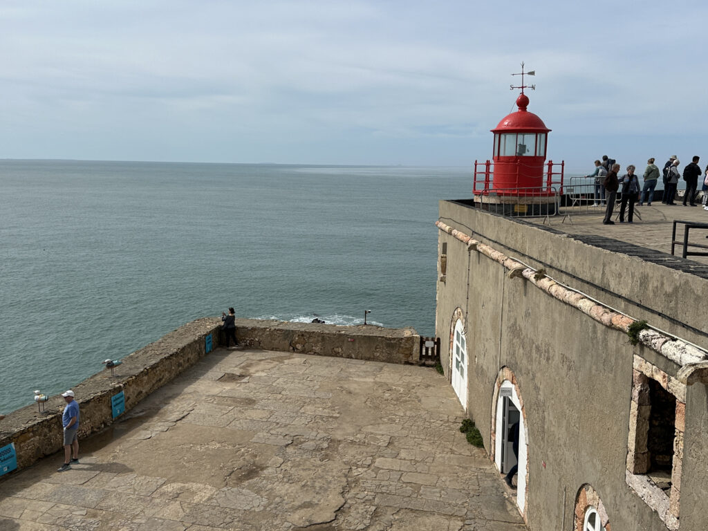a building with a red top and a lighthouse on the top
