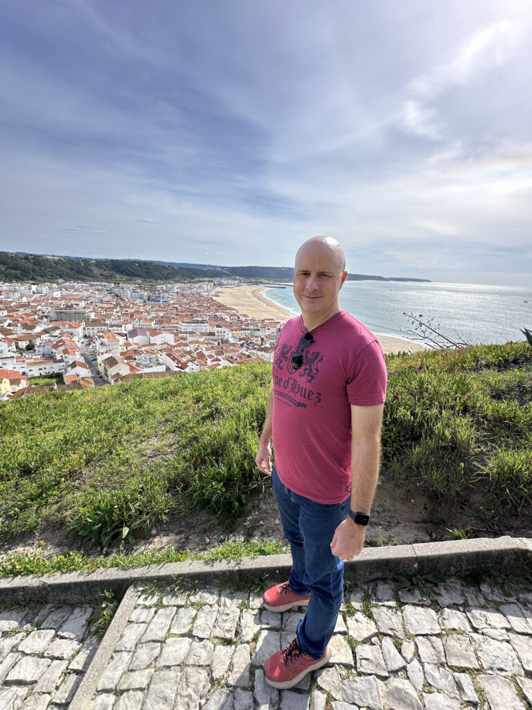 a man standing on a stone path with a city in the background