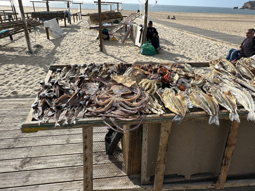 a table with fish on it on a beach