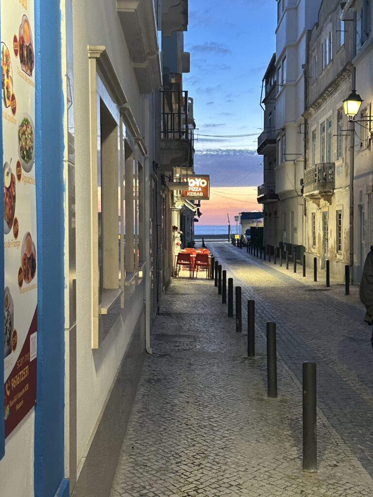 a street with tables and poles on the side