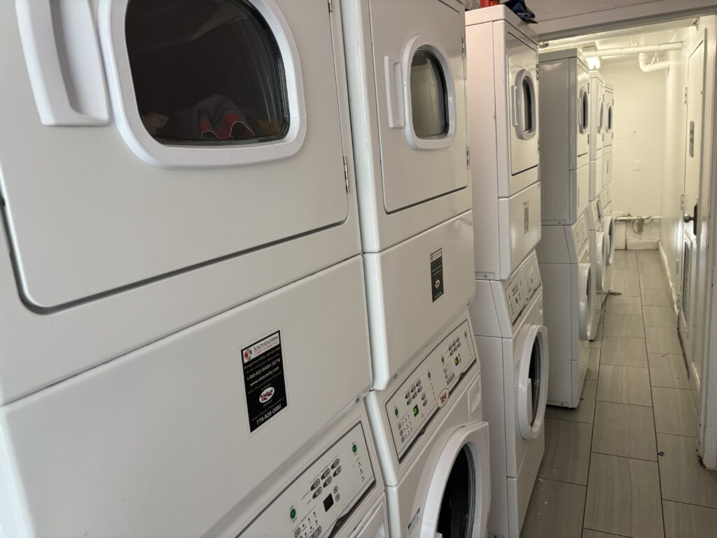 a group of white stacked laundry machines