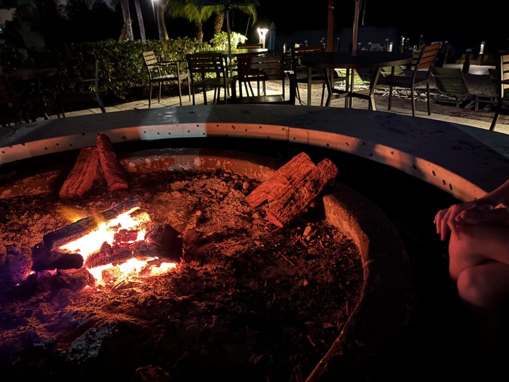 a fire pit with a fire and chairs around it
