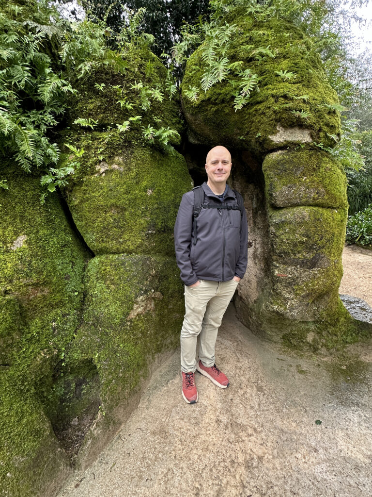 a man standing in front of a rock