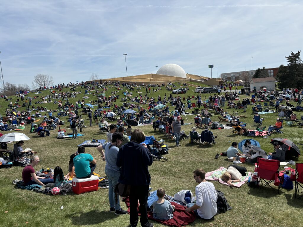 a large group of people sitting on the grass