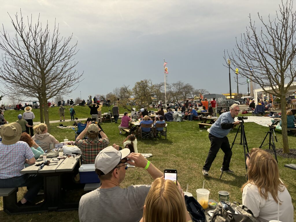 a man taking a picture of a crowd of people in a park