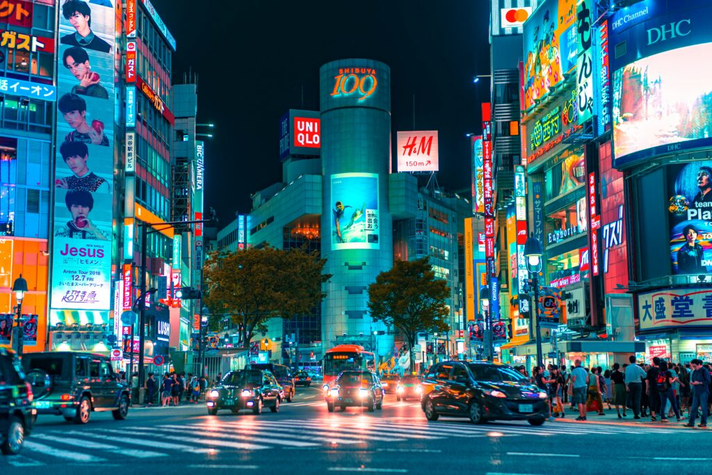 a city street with cars and people walking around