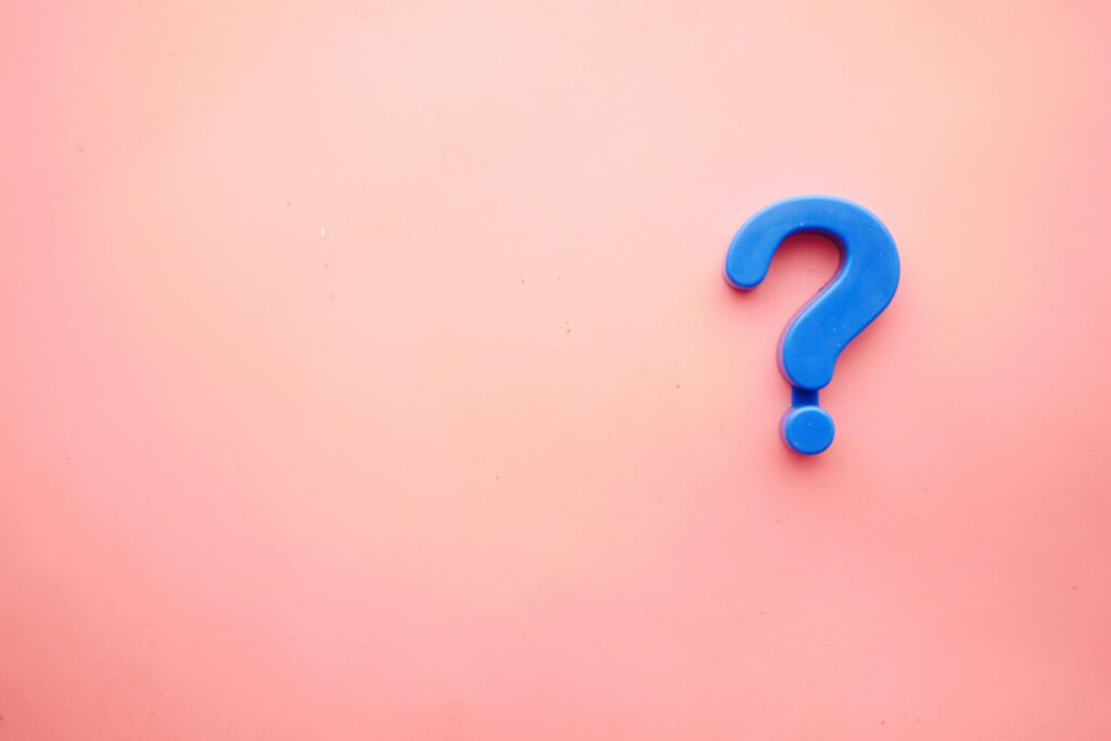 a blue question mark on a pink surface