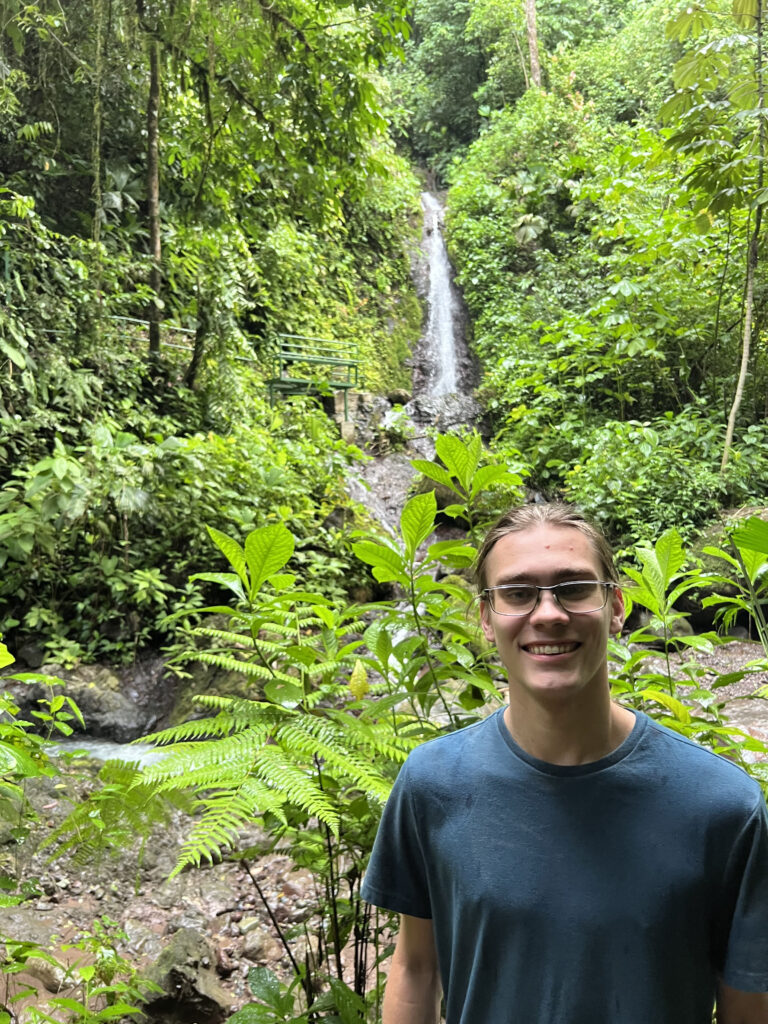 a man standing in front of a waterfall