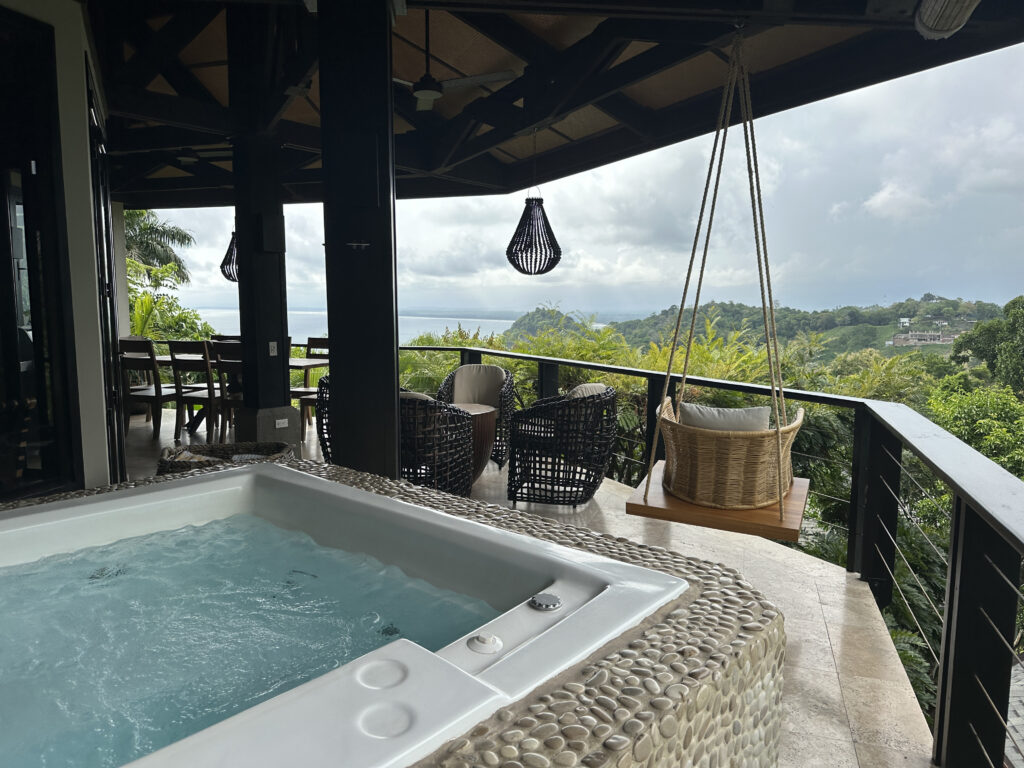 a hot tub on a deck with a swing from it