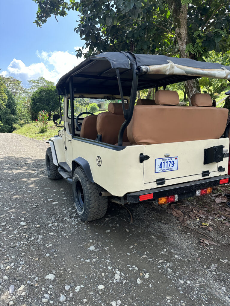 a white jeep with brown seats on a gravel road