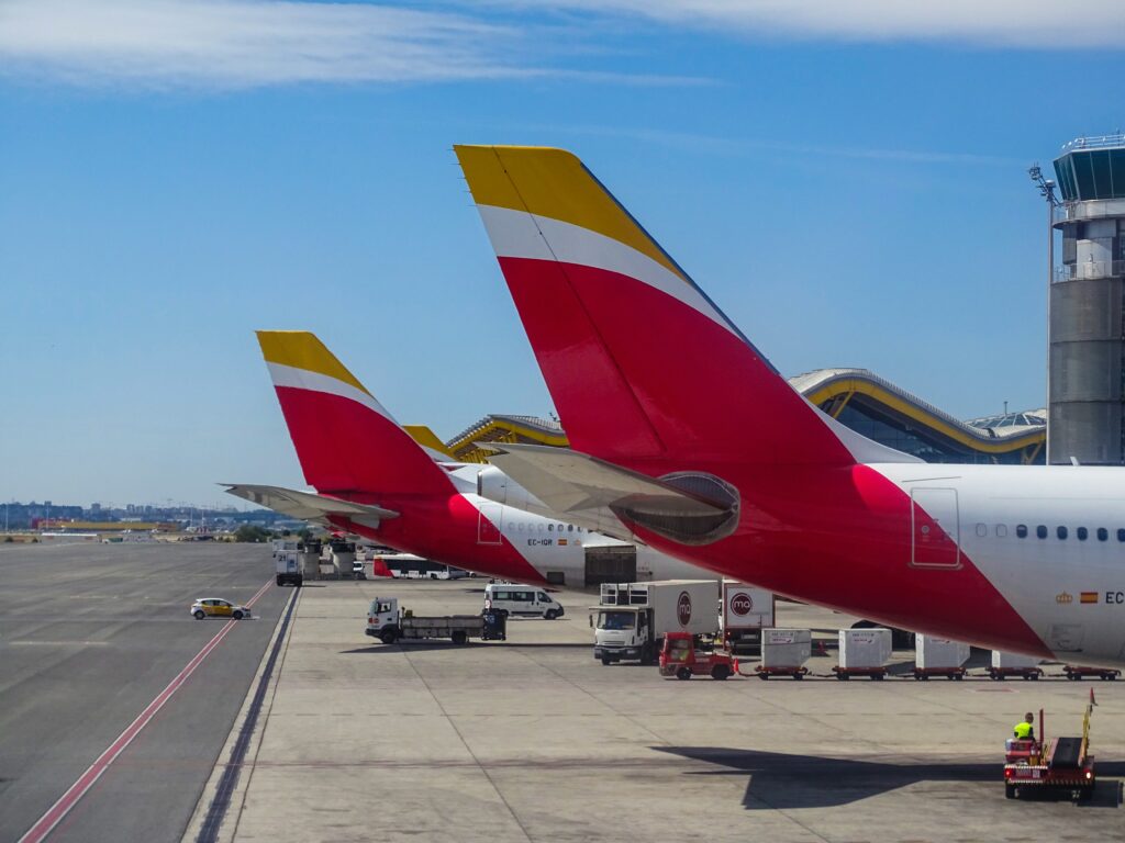 red and yellow tail fins of airplanes at an airport