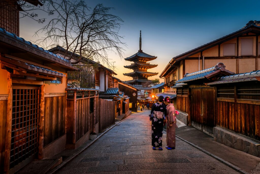 people standing on a street with a tall tower in the background