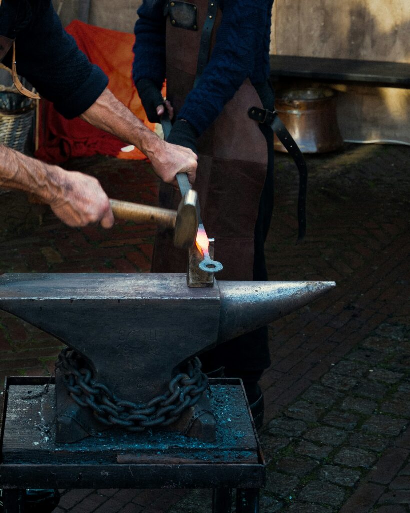 a person using hammer to make a hot metal object