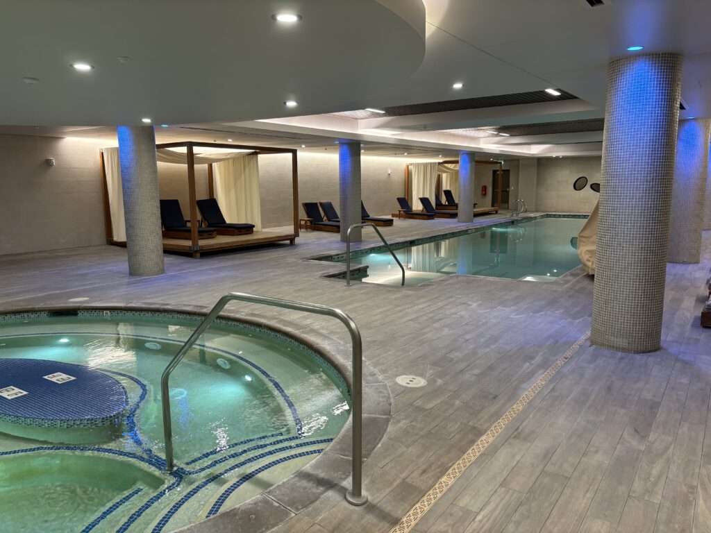 a indoor pool with a hot tub and chairs