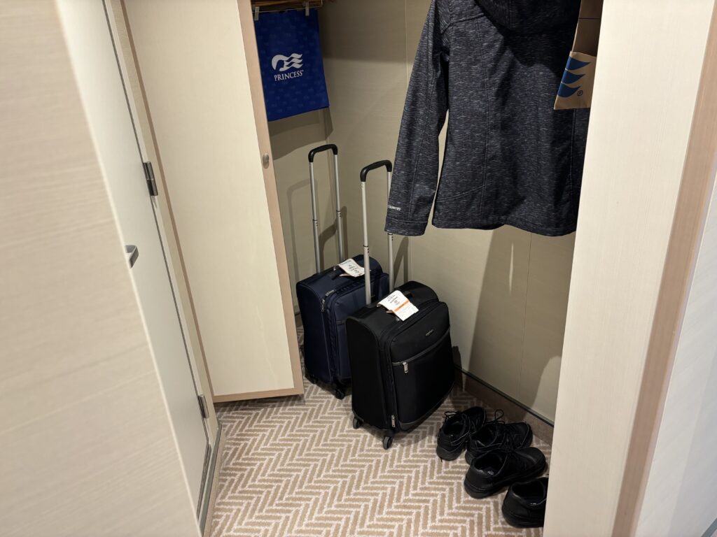 a coat and luggage in a closet