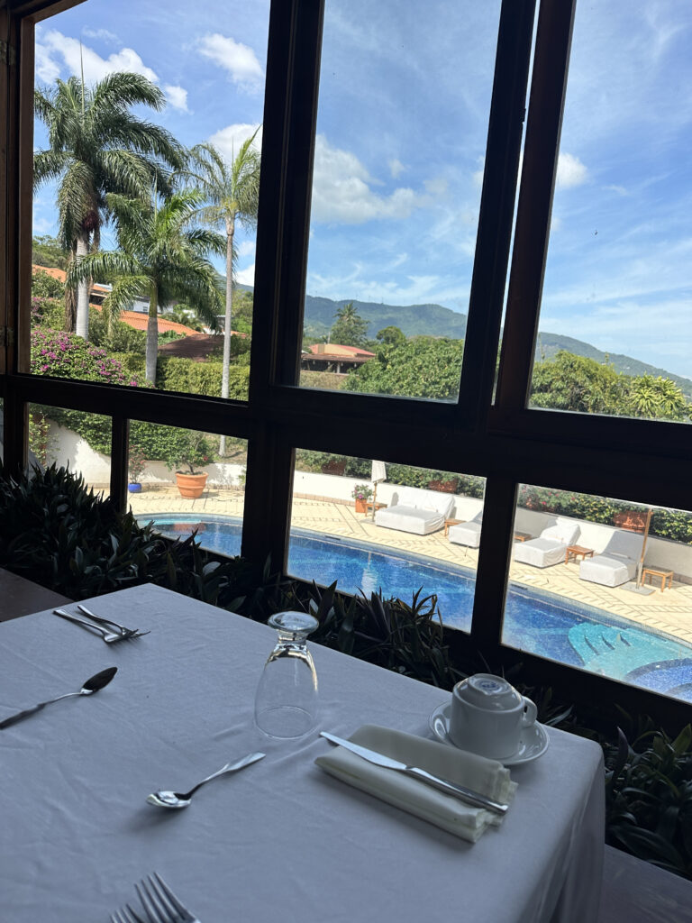 a table with a white tablecloth and silverware next to a pool
