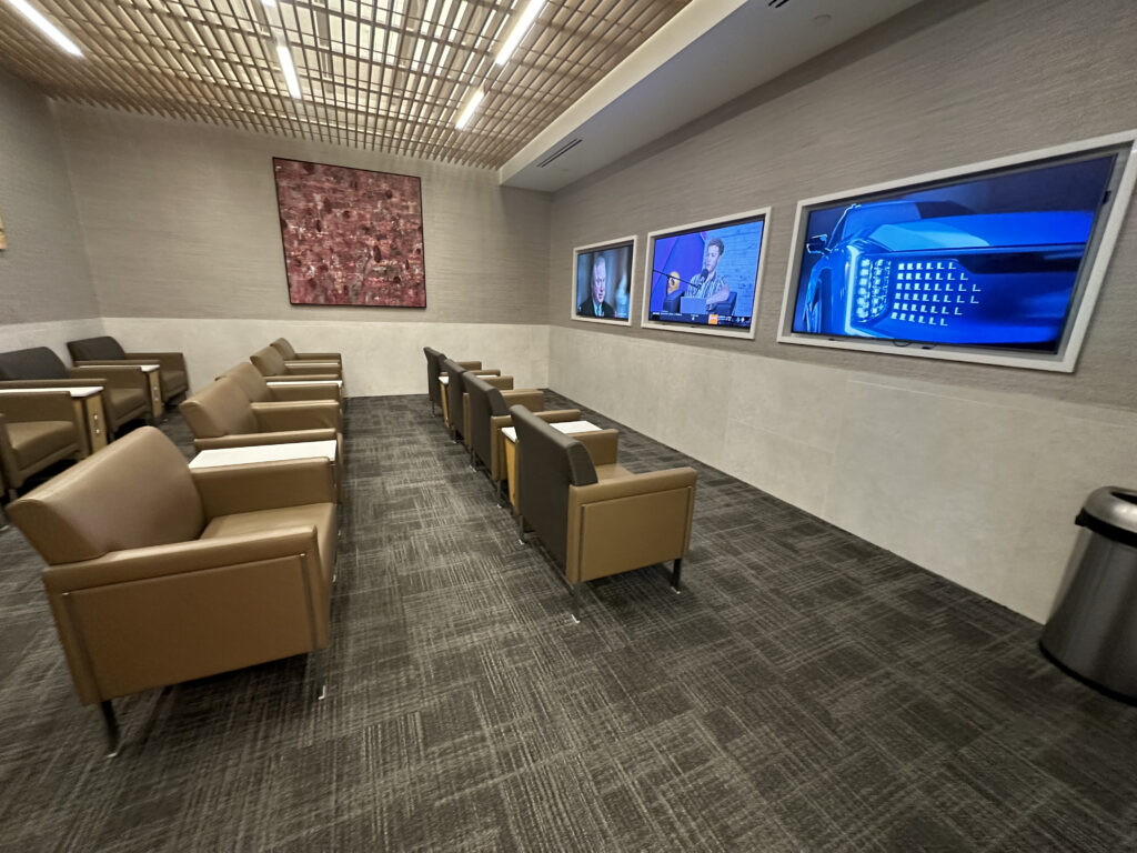 a room with chairs and televisions on the wall