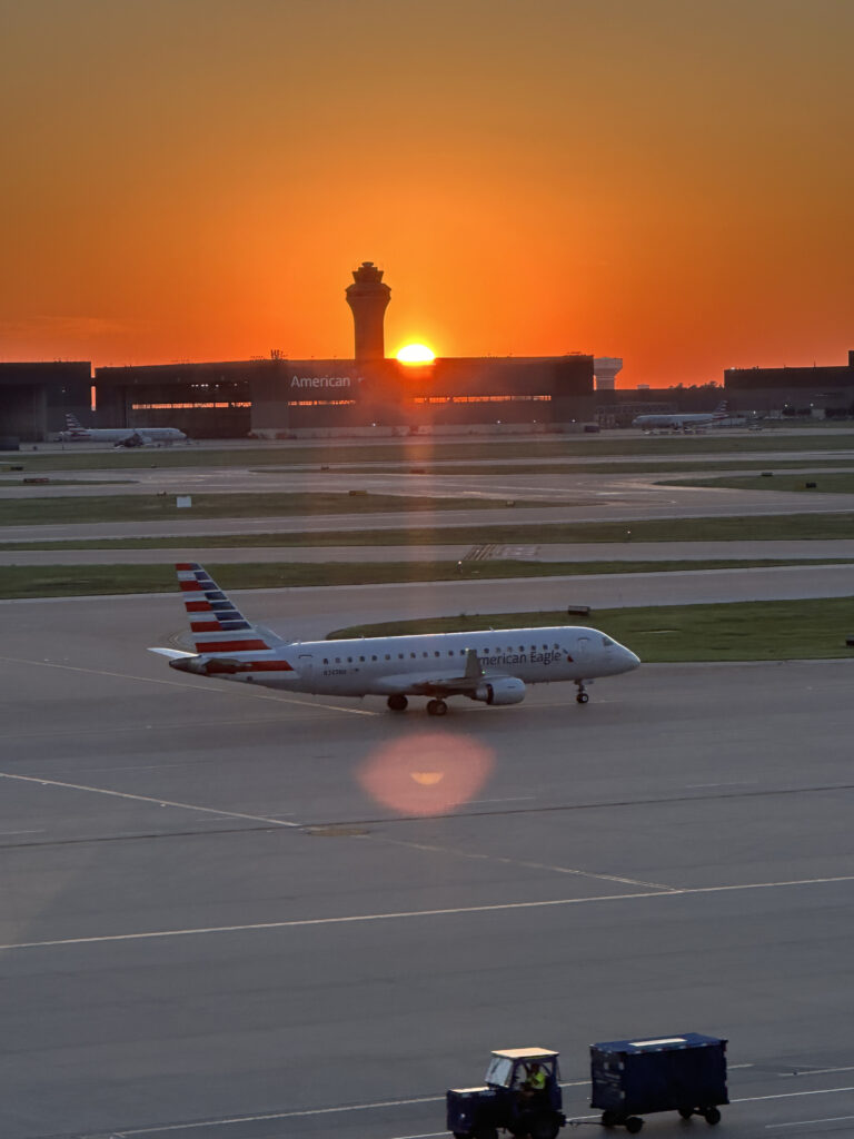 an airplane on a runway at sunset